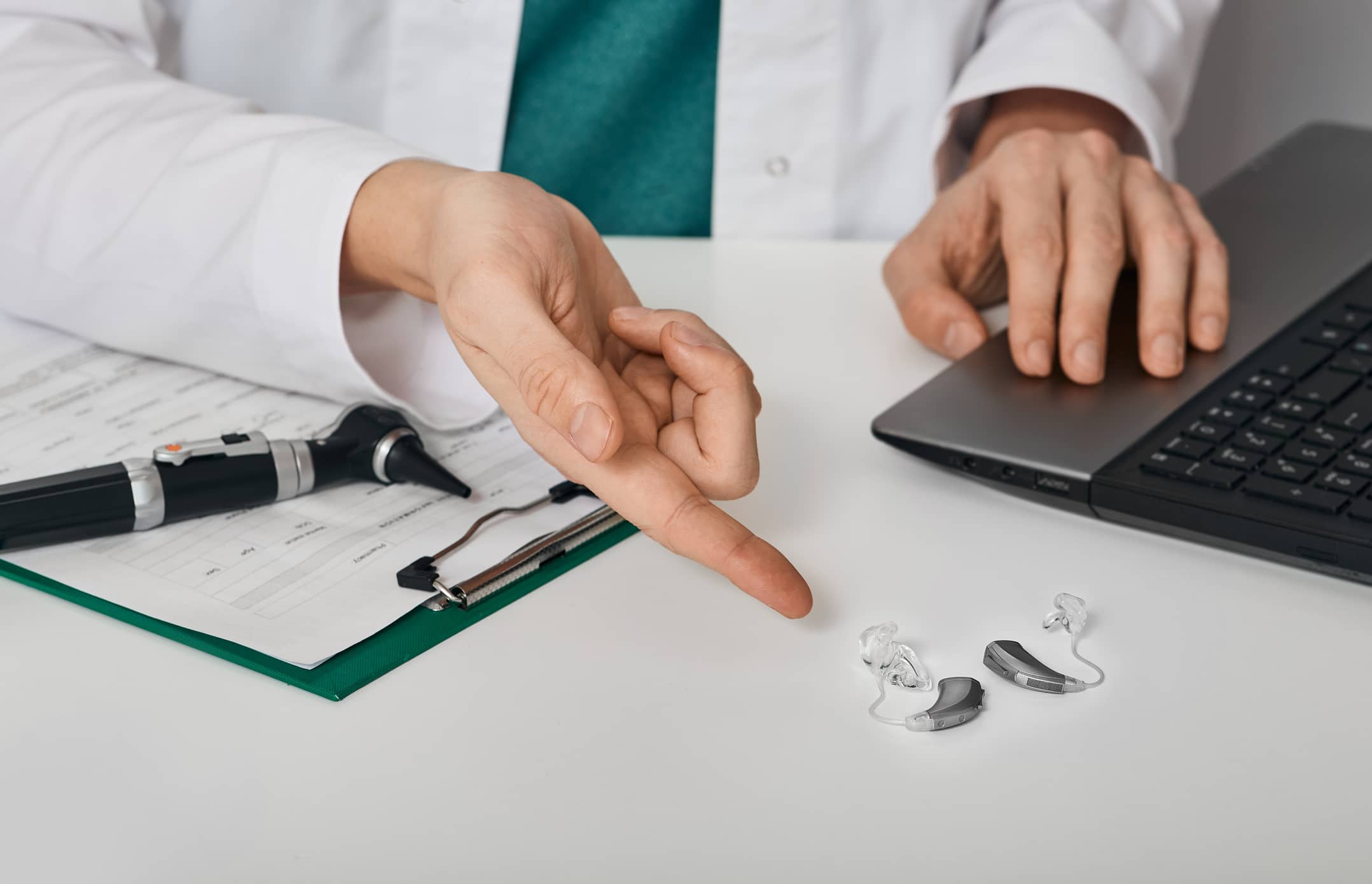 Audiologist advising patient to use BTE hearing aids to treat deafness while consultation at hearing clinic. Audiology, hearing solutions Audiologist advising patient to use BTE hearing aids to treat deafness while consultation at hearing clinic. Audiology, hearing solutions