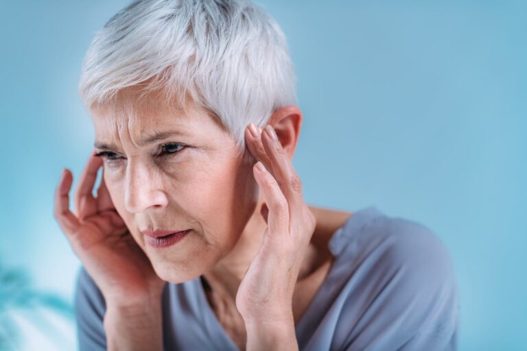 Woman with tinnitus holds ears